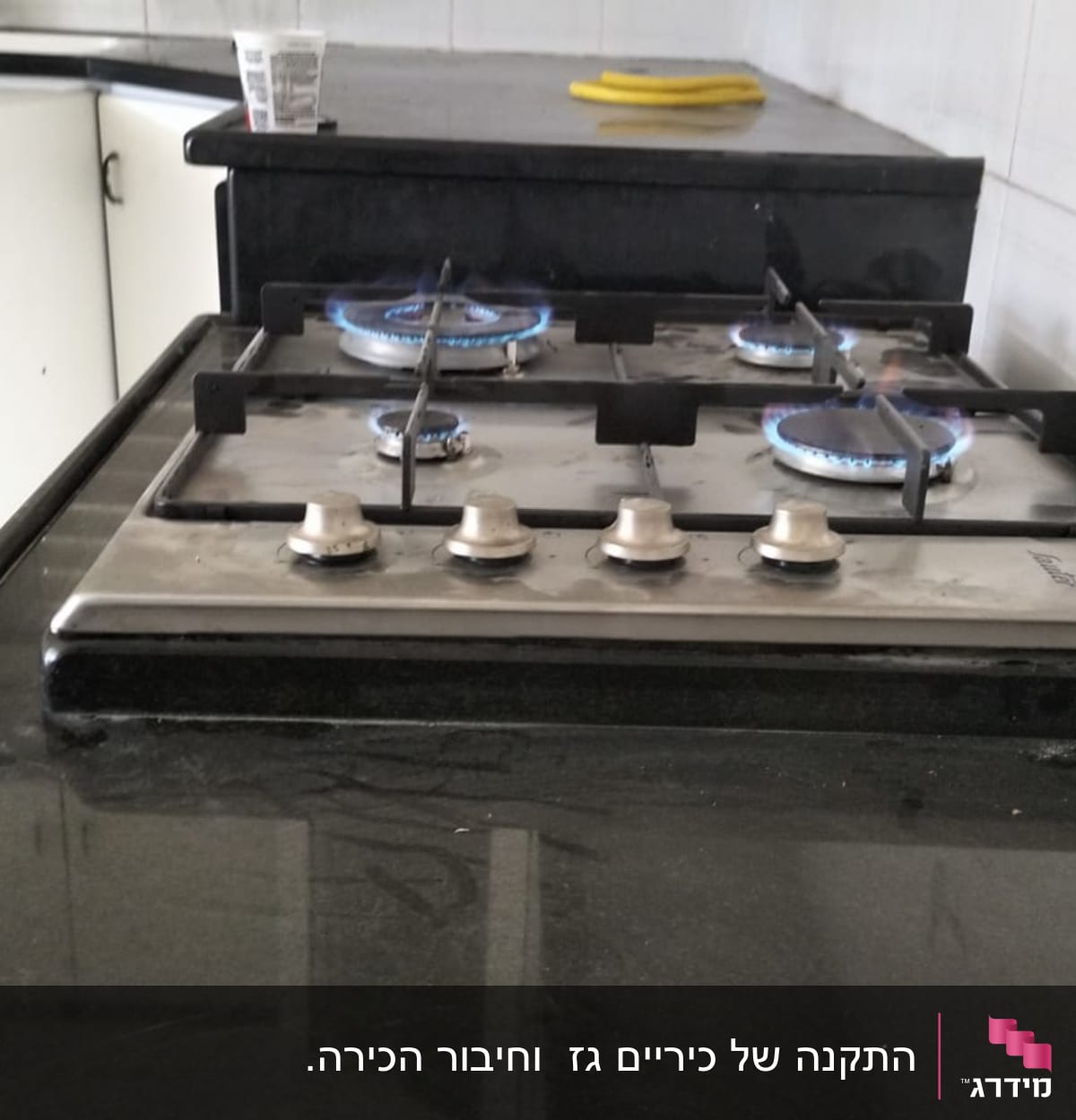 כיריים גז עם ארבעה מבערים דולקים במטבח